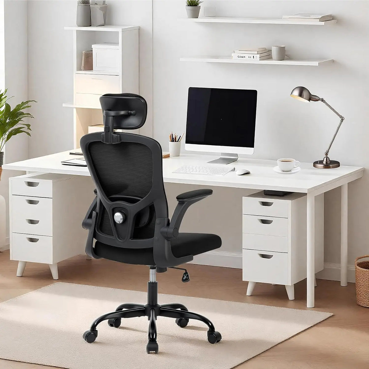 Chaise de bureau ergonomique noire installée devant un bureau de télétravail